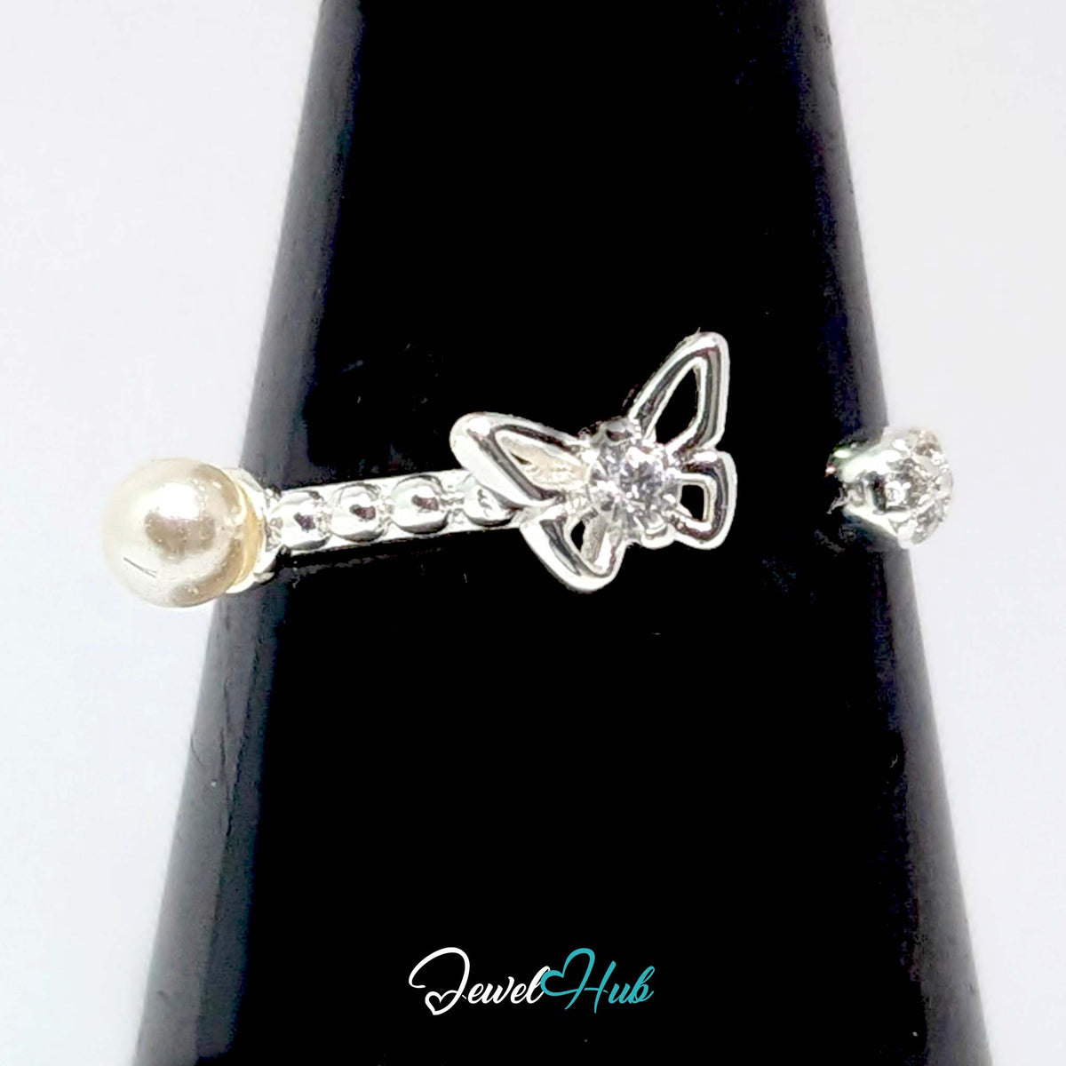 Butterfly ring against a black cone, showing the butterfly, faux pearl and crystal - JewelHub
