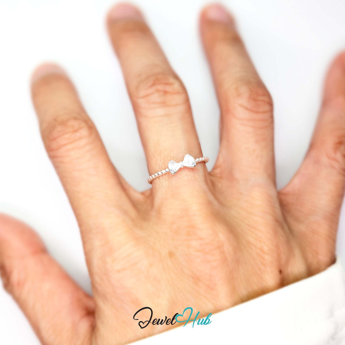 Bow ring worn on a hand, showing the fit of the adjustable M-O band - JewelHub