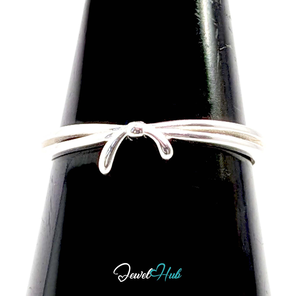 Ribbon ring against a black cone, showing the untied bow across the band - JewelHub