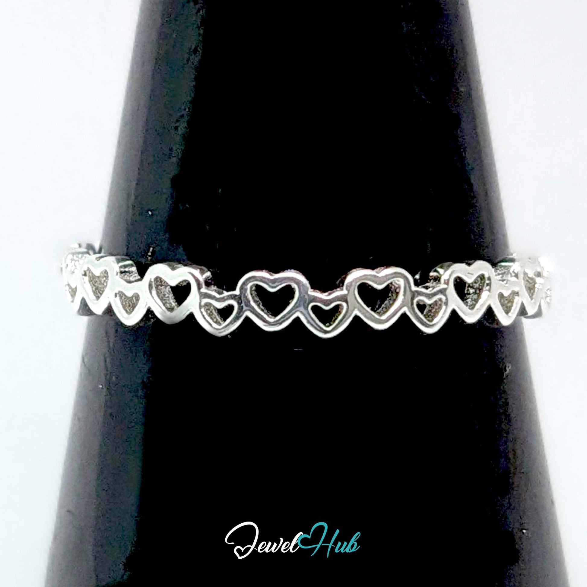 Linked hearts band against a black cone, the open hearts silhouetted - JewelHub