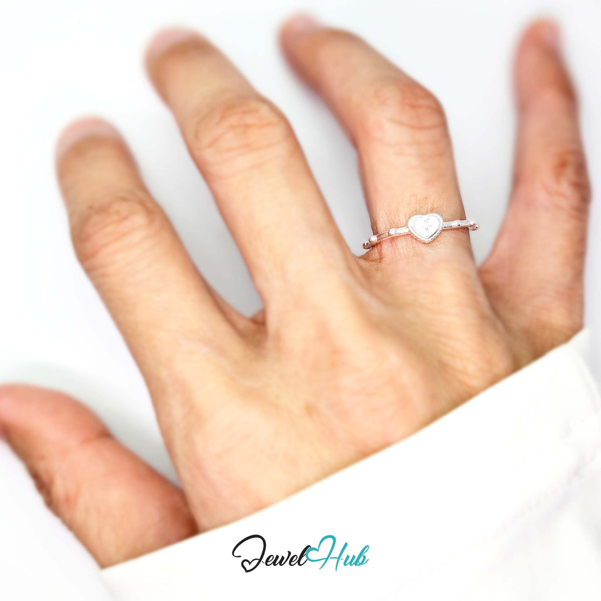 Cross heart ring worn on a hand, showing the fit of the smaller J-L band - JewelHub