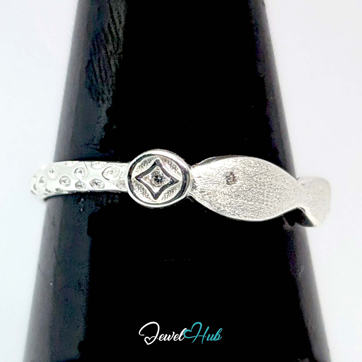 Coin and fish ring on a black cone display, showing the raised coin motif - JewelHub
