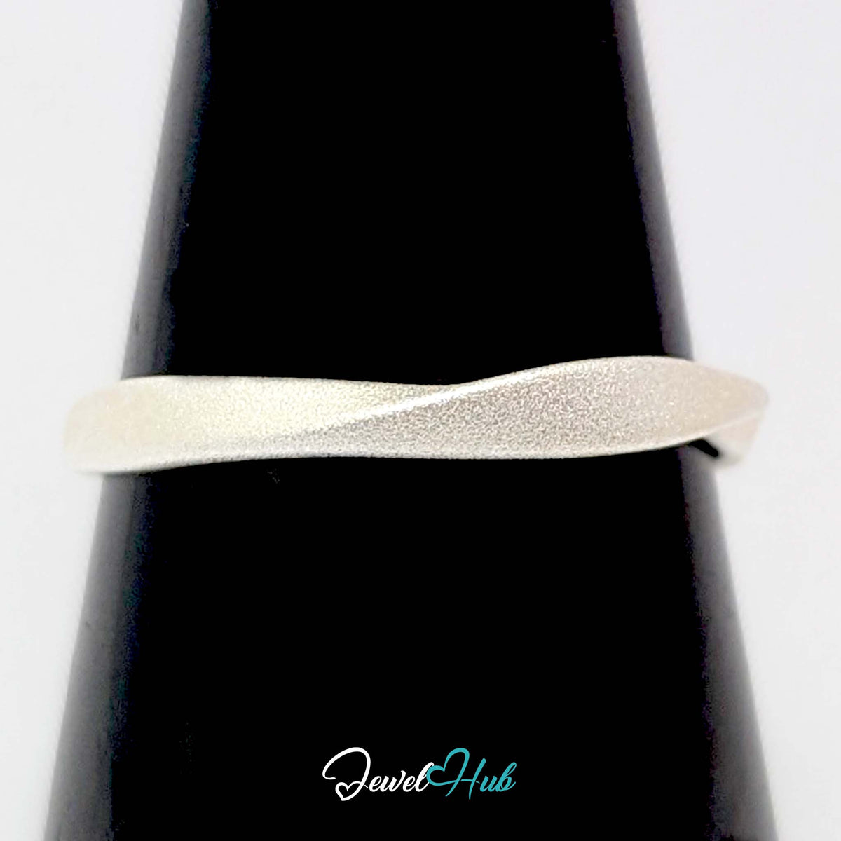 Mobius twist ring on a black cone display, showing the half turn in the band - JewelHub