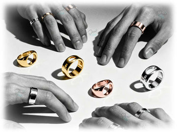 Gold and rose gold rings displayed on a white surface with hands around them.