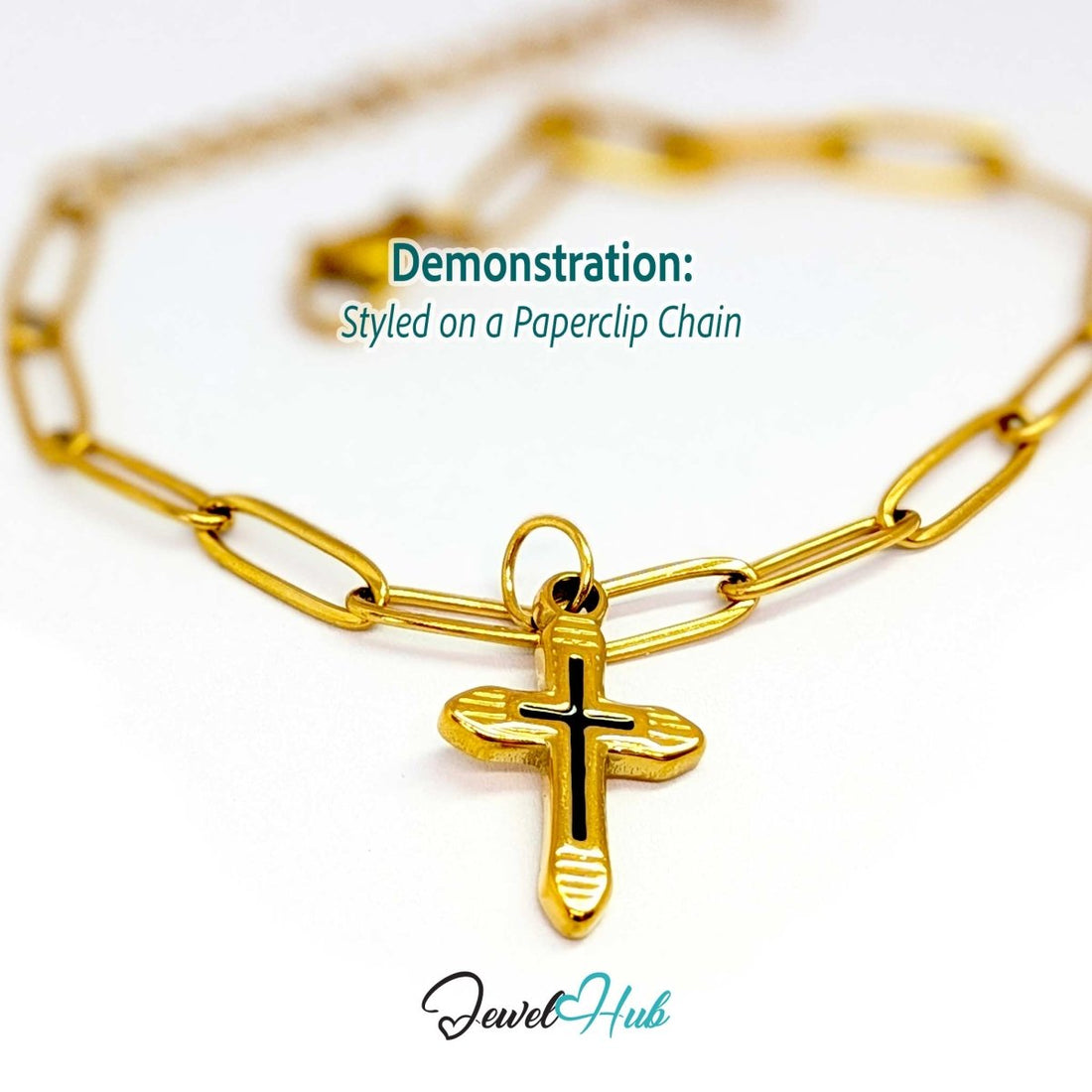 Cross charm in gold stainless steel with a black enamel inlay - styled on a gold paperclip chain bracelet - JewelHub