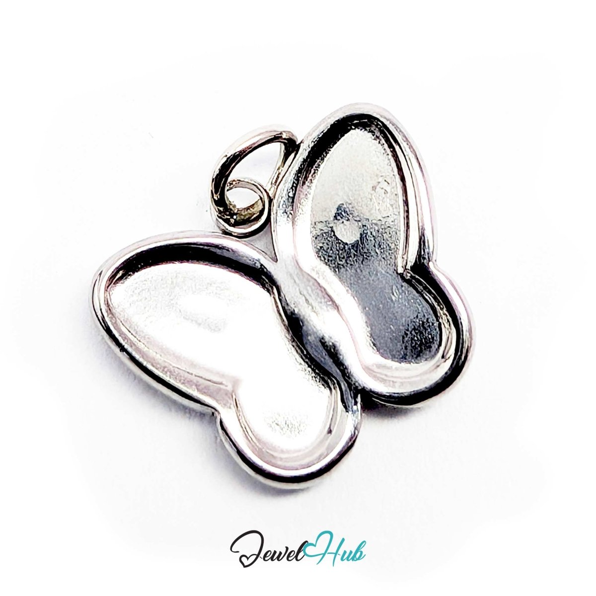 Silver butterfly charm tilted forward to show the raised outline framing the wings - JewelHub