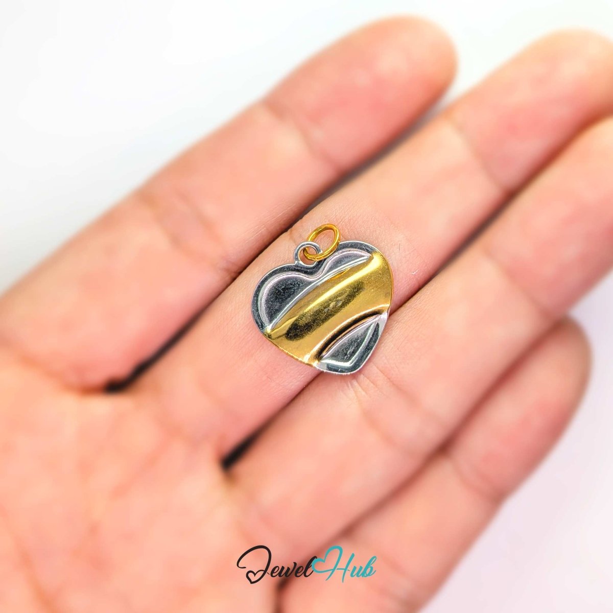 Two-tone Curve Heart charm held in the hand to show its 17.3mm width - JewelHub