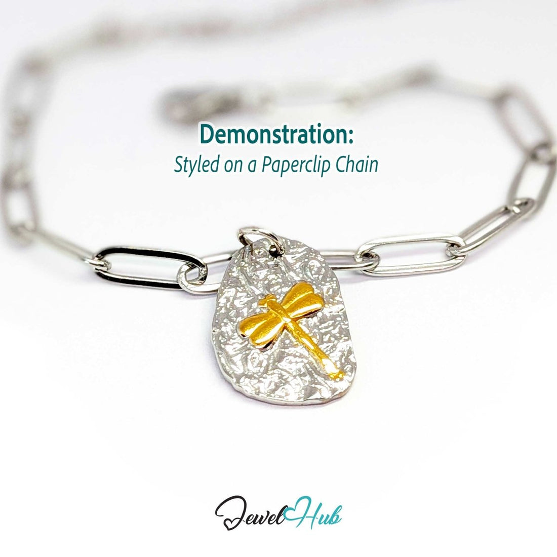 Two-tone dragonfly charm hanging from a silver paperclip chain bracelet - JewelHub