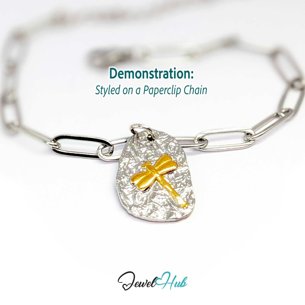 Two-tone dragonfly charm hanging from a silver paperclip chain bracelet - JewelHub