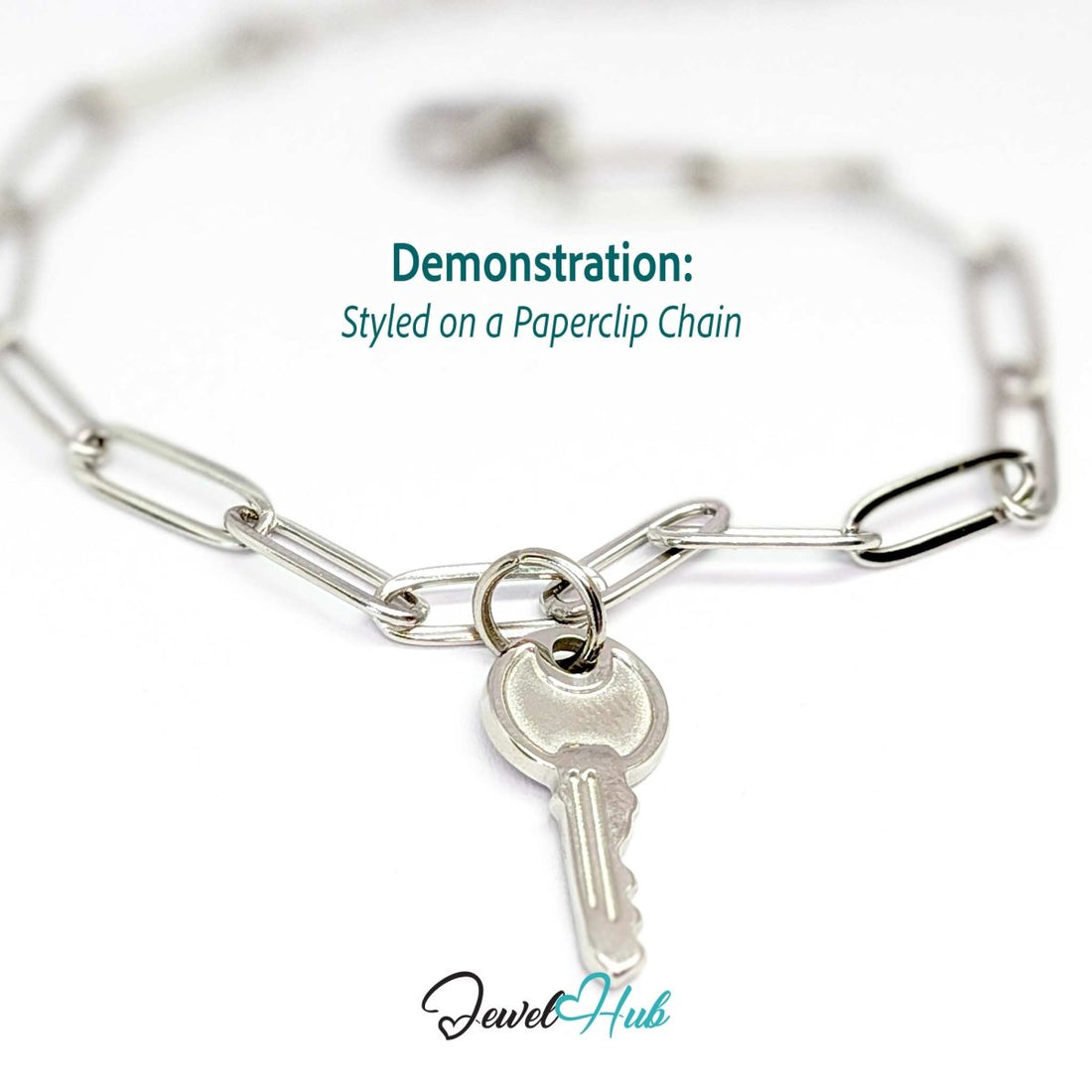 Everyday key charm in silver stainless steel with a plain round head - styled on a silver paperclip chain bracelet - JewelHub