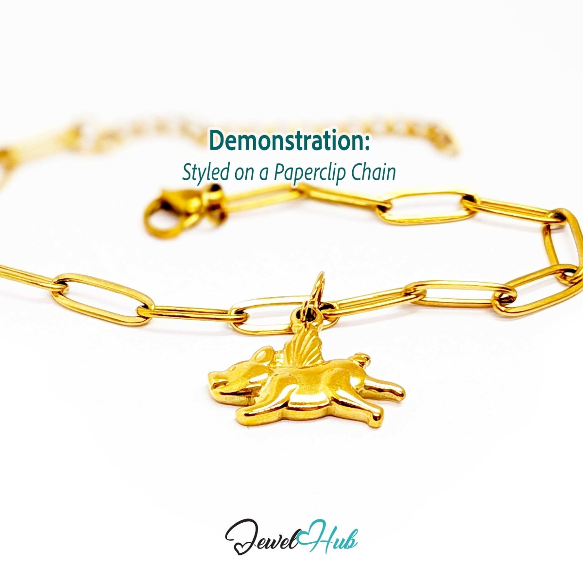 Gold flying pig charm styled on a gold paperclip chain bracelet - JewelHub