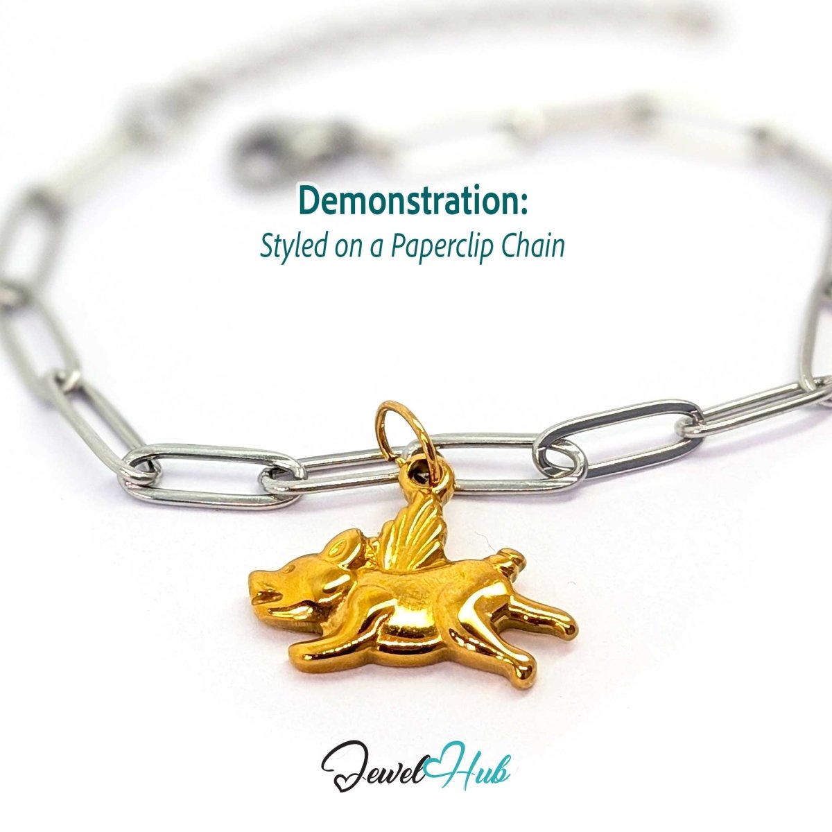 Gold flying pig charm styled on a silver paperclip chain bracelet for a two-tone look - JewelHub