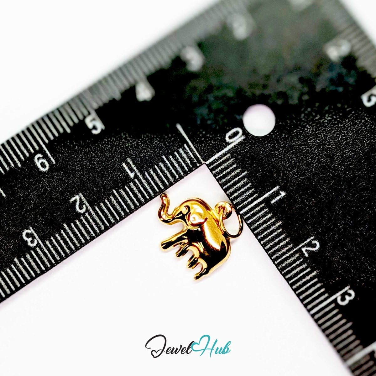 Gold elephant charm measured against a ruler at 15.5mm wide by 14mm tall - JewelHub
