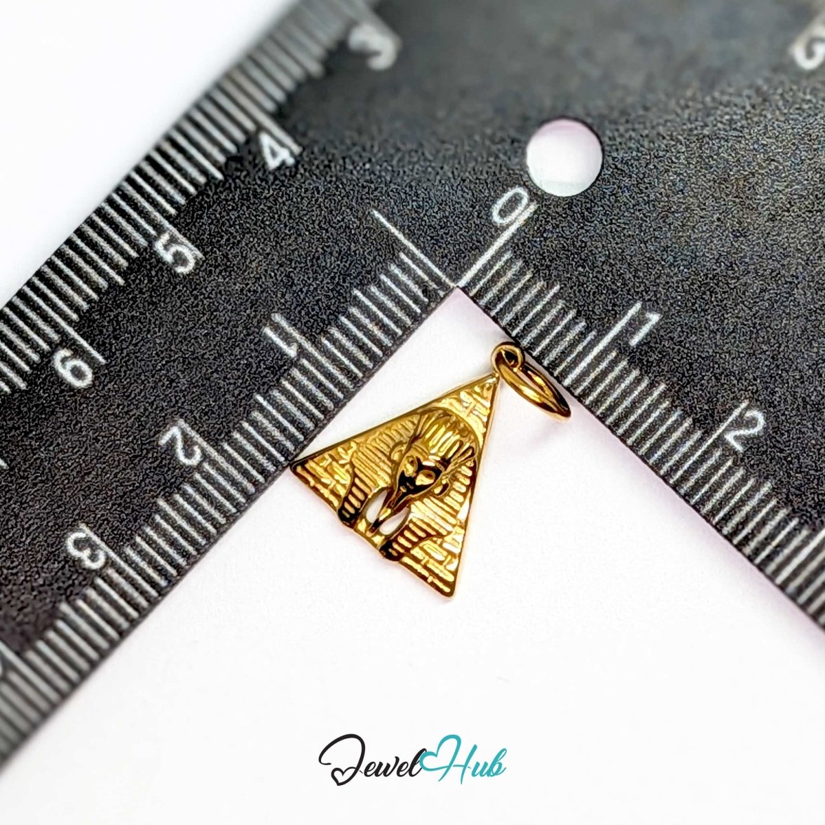 Pyramid and Sphinx charm in gold stainless steel - beside a ruler for scale - JewelHub