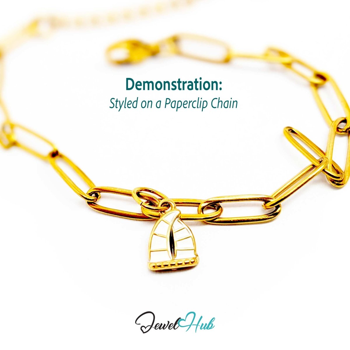 Sailboat charm in gold stainless steel with an openwork sail - styled on a gold paperclip chain bracelet - JewelHub