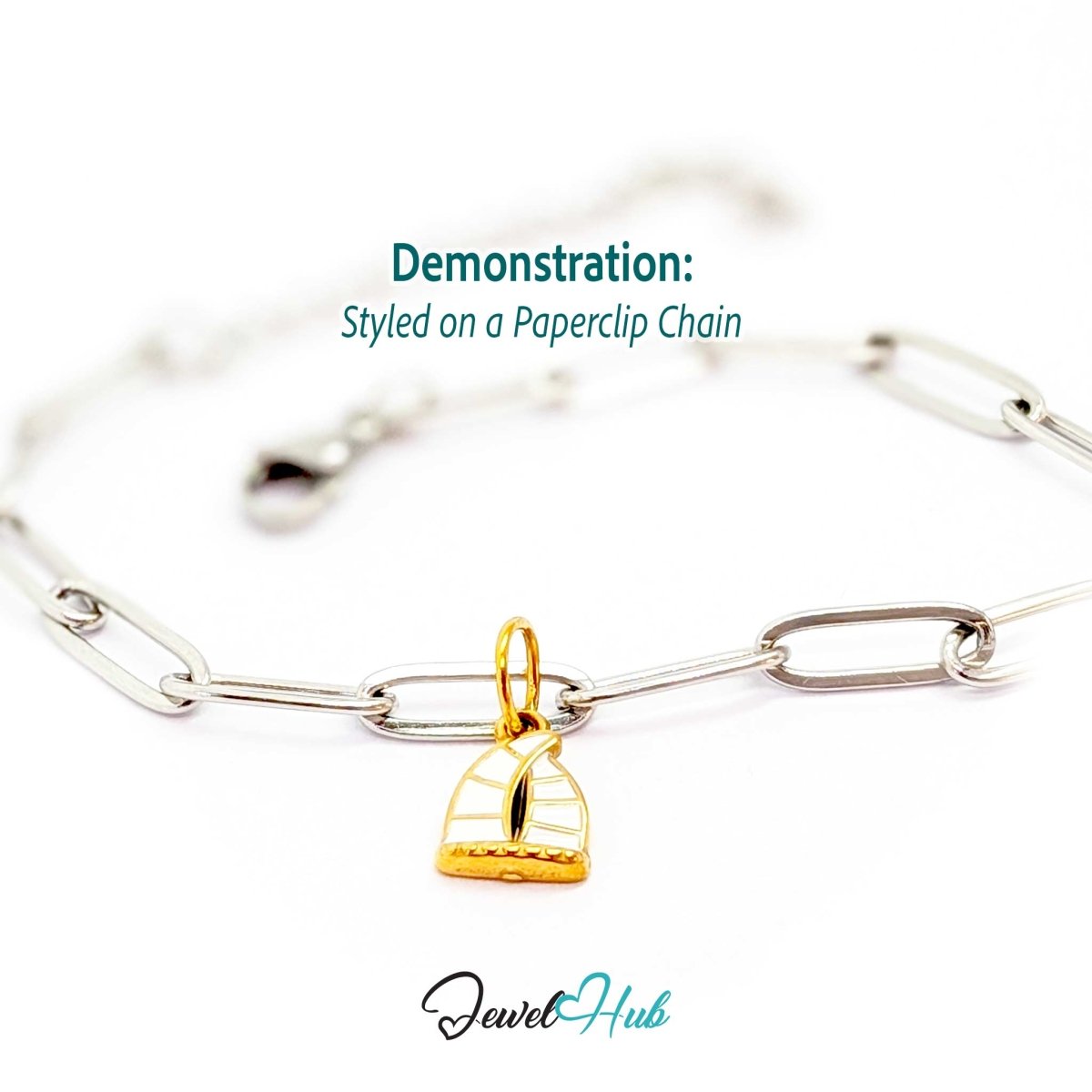 Sailboat charm in gold stainless steel with an openwork sail - styled on a silver paperclip chain bracelet - JewelHub