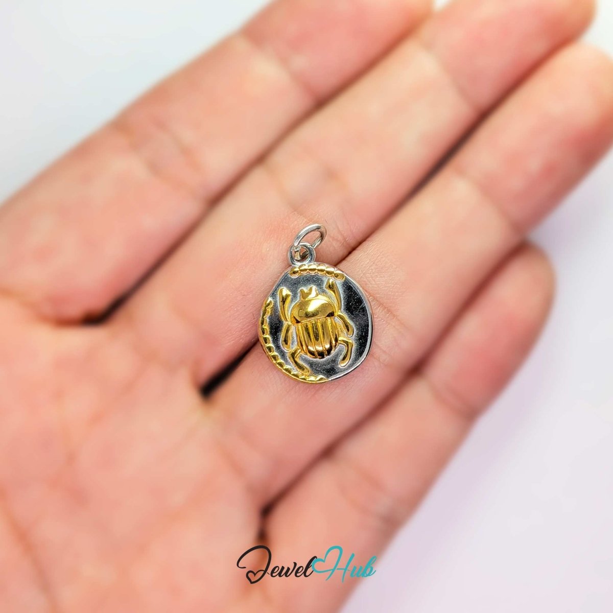 Scarab Oval charm, two-tone stainless steel, held in the hand to show its size - JewelHub