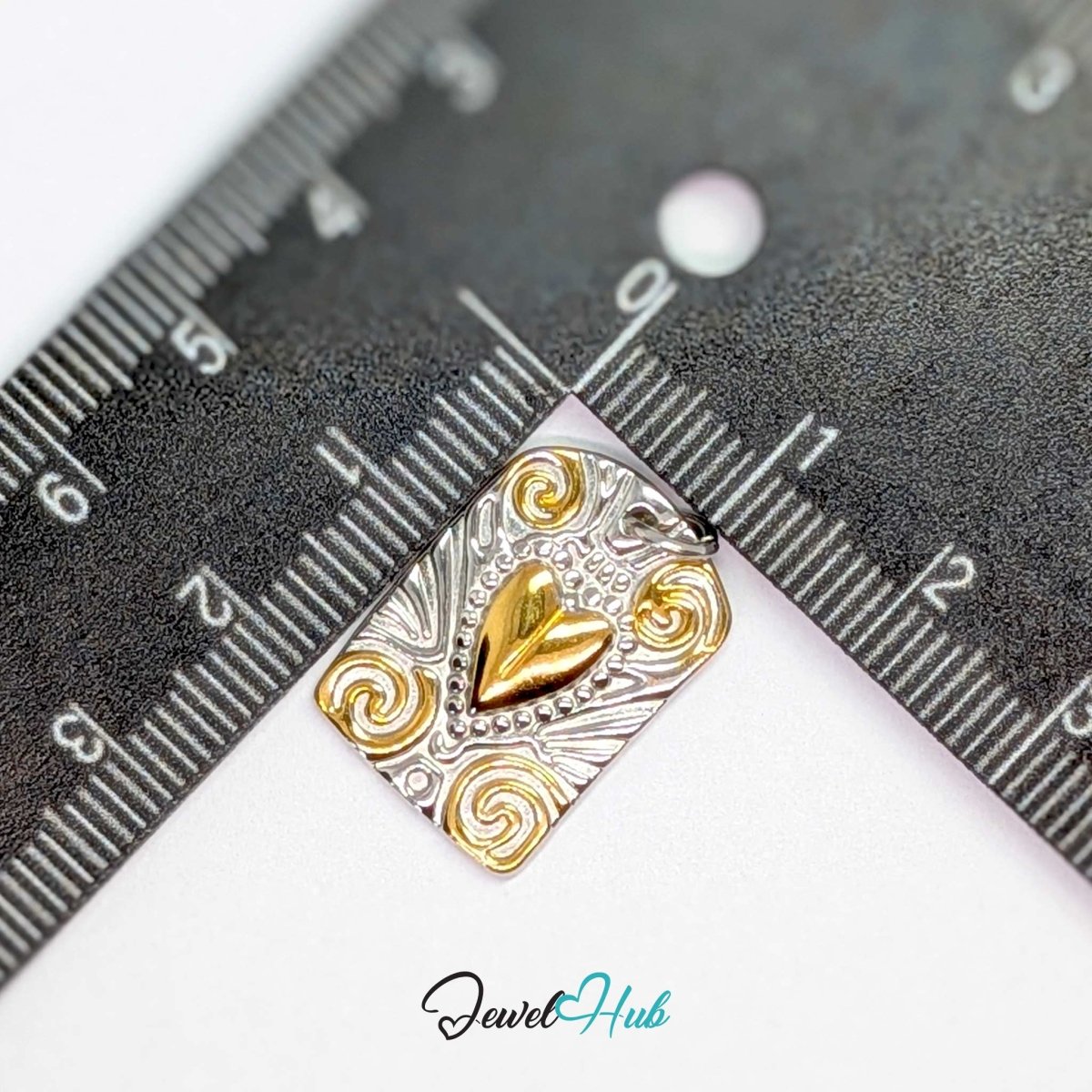 Scroll Plaque charm measured against a ruler at 15mm wide by 21.5mm tall - JewelHub