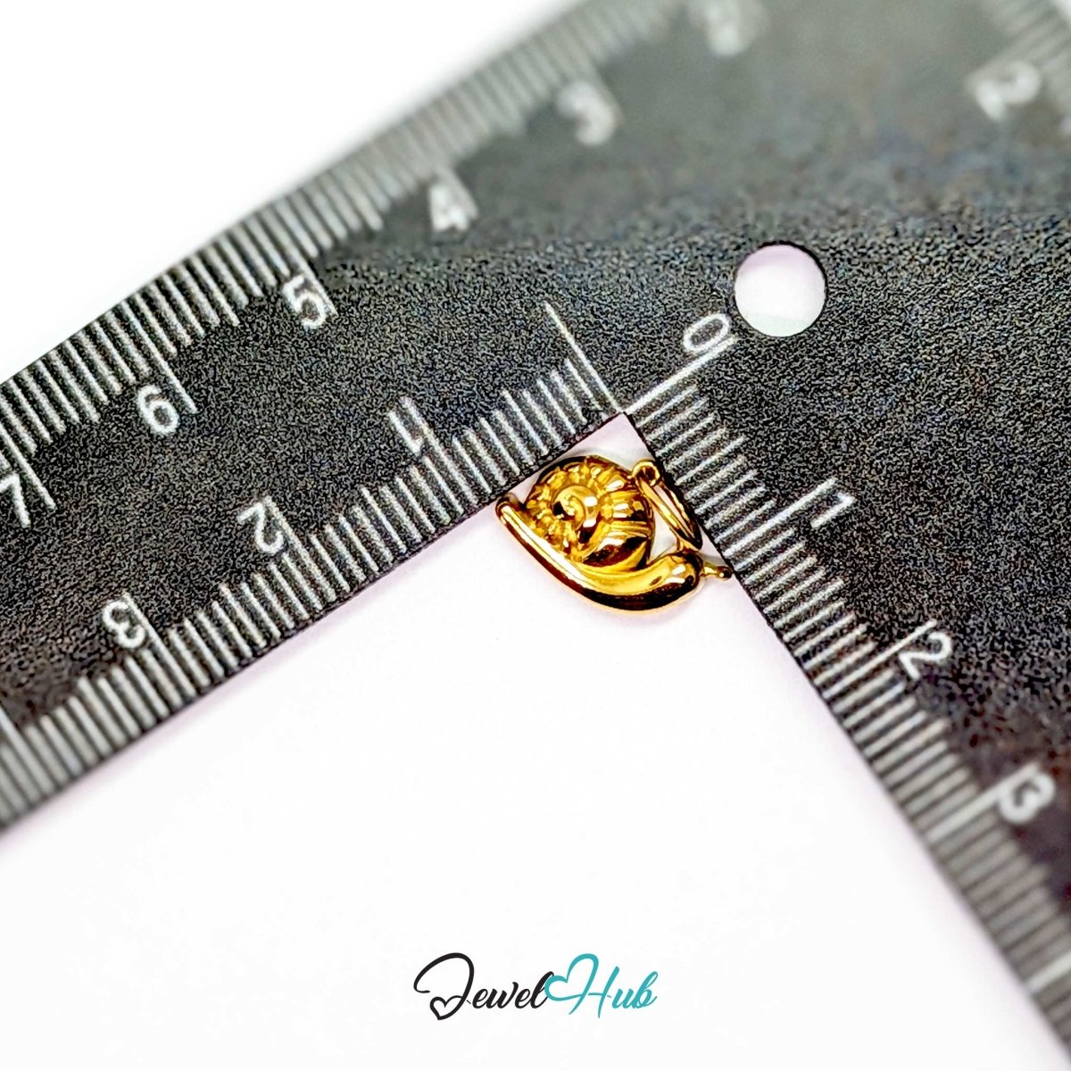 Gold snail charm measured against a ruler at 14.3mm wide by 9mm tall - JewelHub