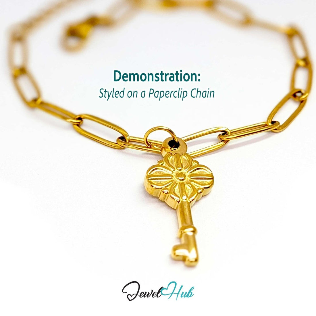 Vintage key charm in gold stainless steel with a quatrefoil bow - styled on a gold paperclip chain bracelet - JewelHub