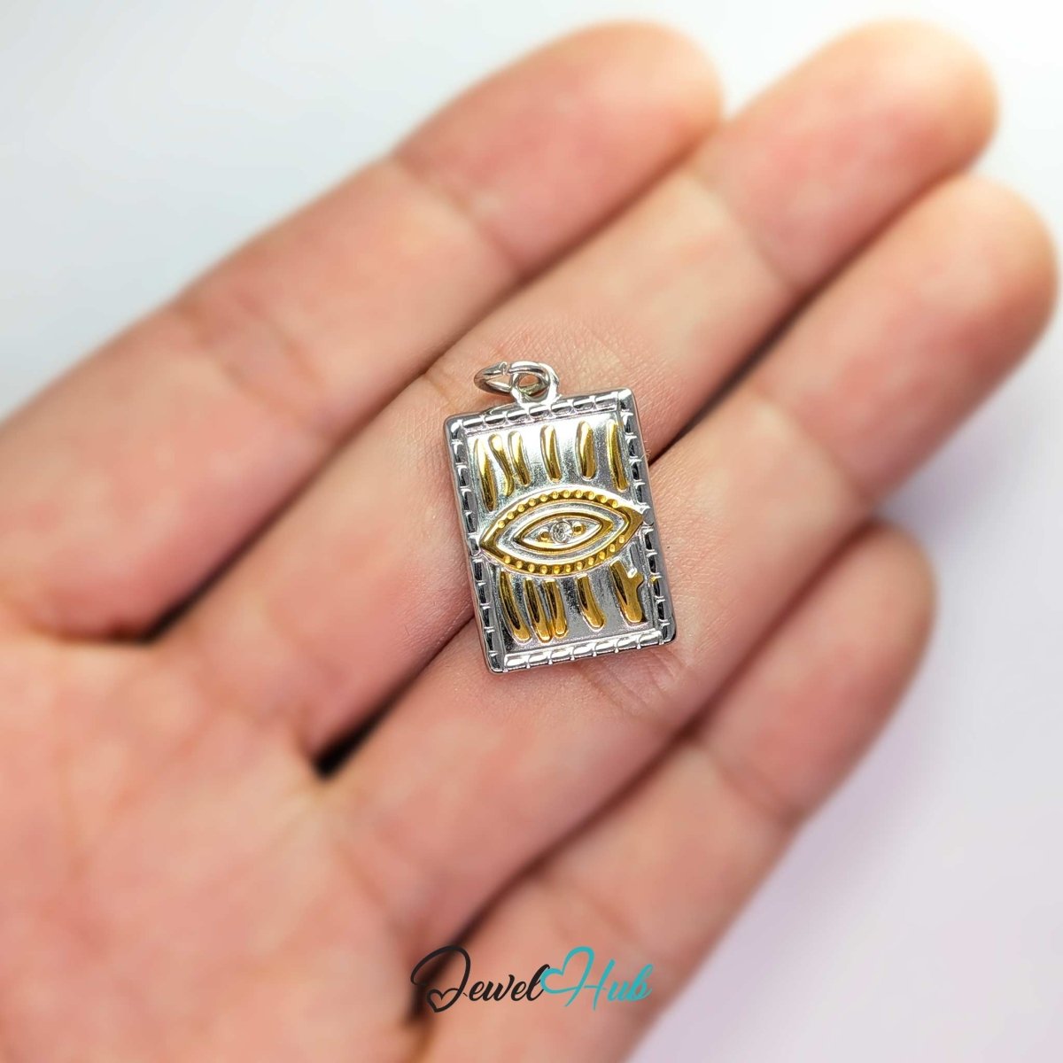 Evil Eye Plate charm, two-tone stainless steel, held in the hand to show its size - JewelHub