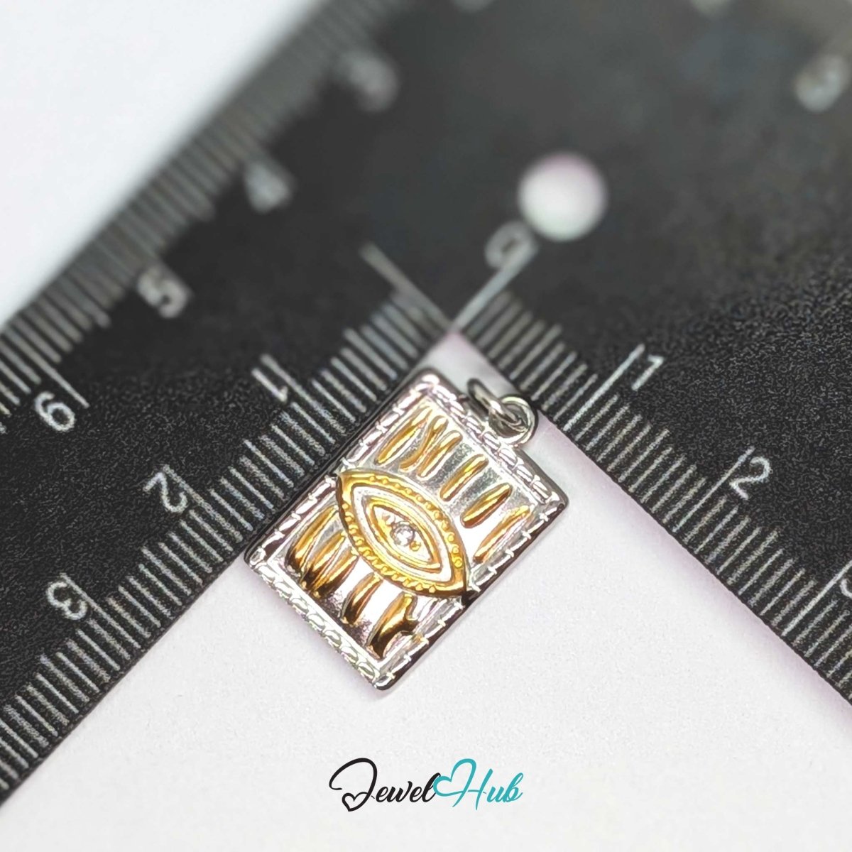 Evil Eye Plate charm, two-tone stainless steel, measured against a ruler at 13.7 x 21.3mm - JewelHub