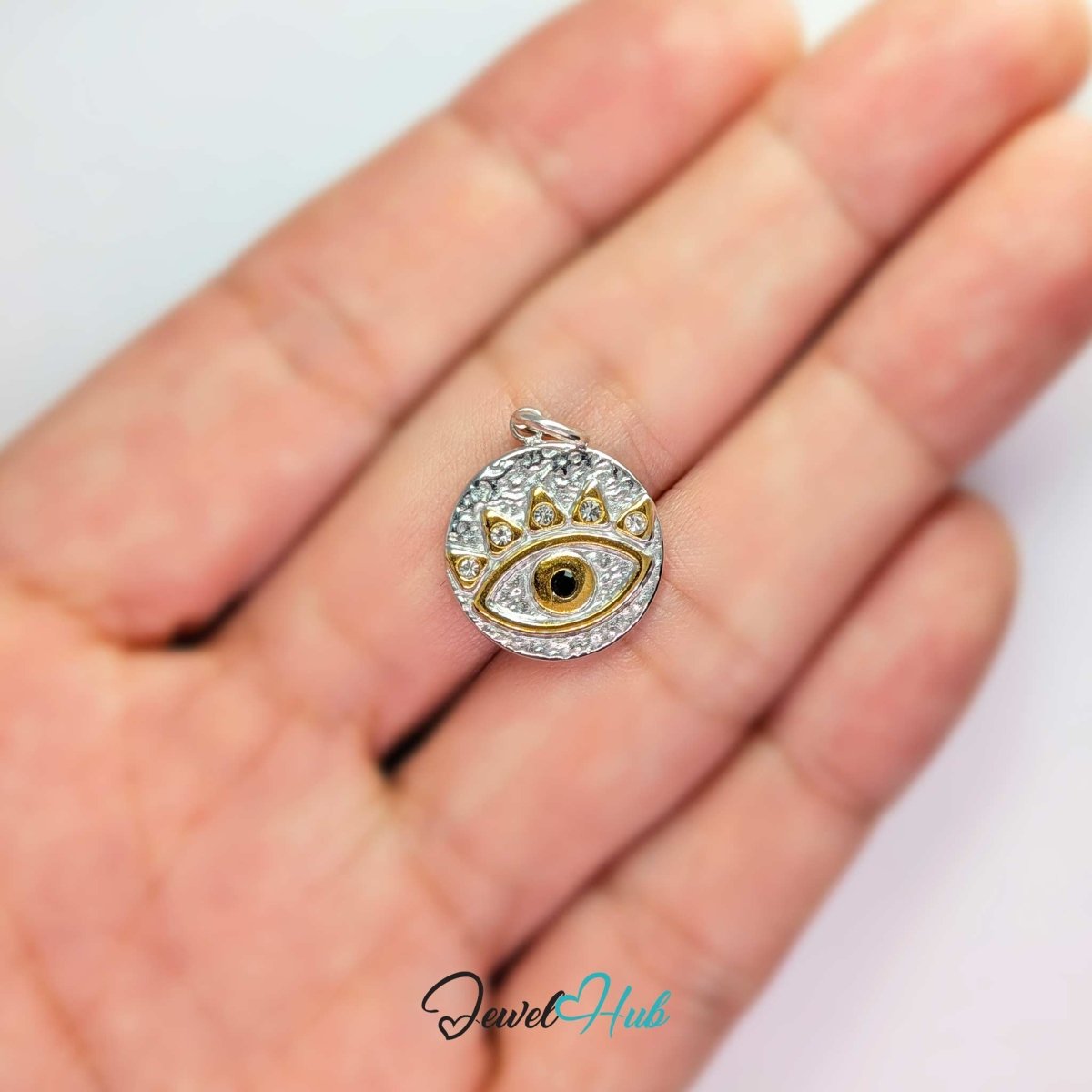 Evil Eye Round charm, two-tone stainless steel, held in the hand to show its size - JewelHub