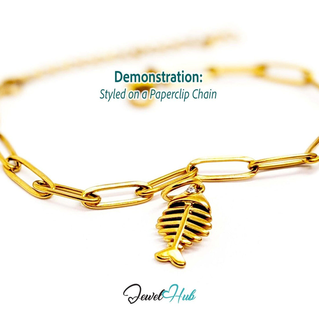 Fish bone charm in gold stainless steel with a crystal eye - styled on a gold paperclip chain bracelet - JewelHub