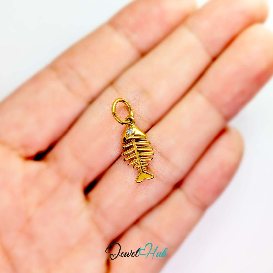 Fish bone charm in gold stainless steel with a crystal eye - front view - JewelHub