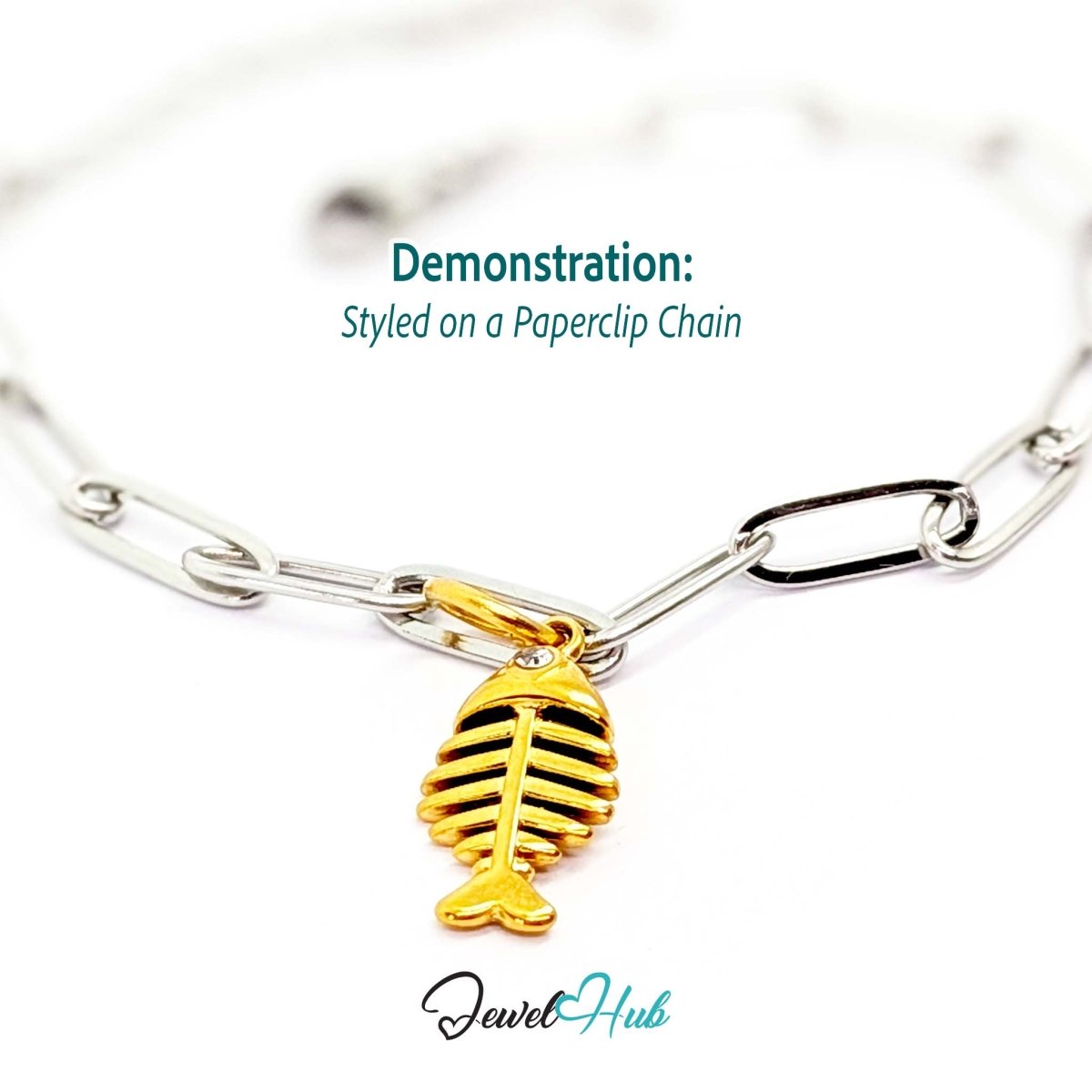Fish bone charm in gold stainless steel with a crystal eye - styled on a silver paperclip chain bracelet - JewelHub