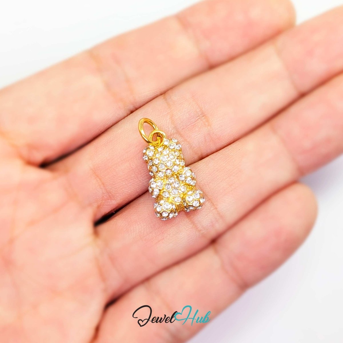 Gold Crystal Gummy Bear charm held in the hand to show its 18mm scale - JewelHub