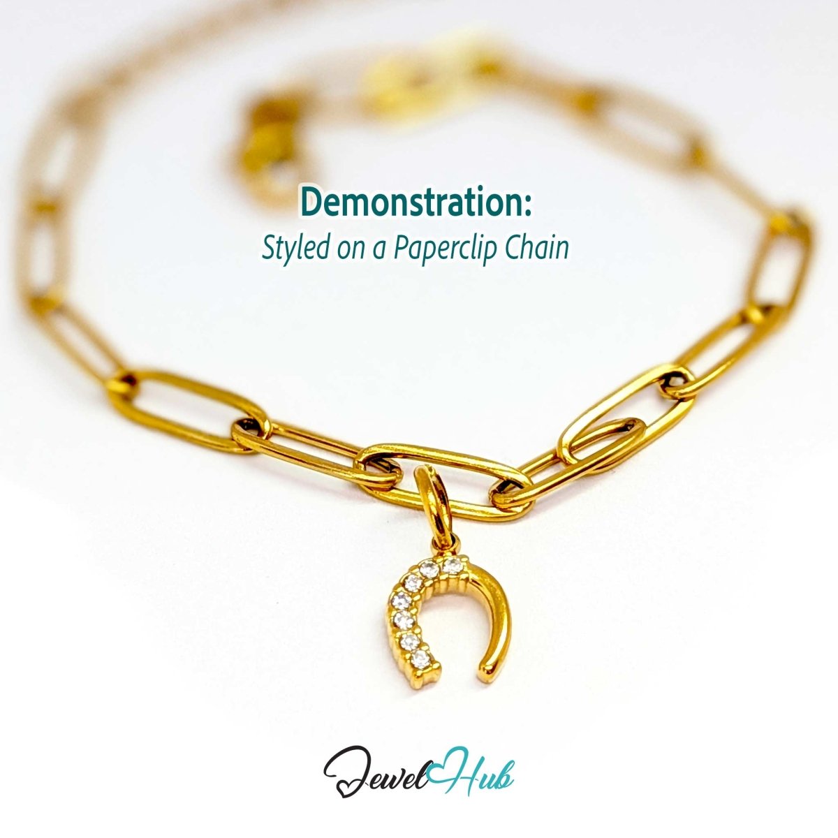Mini horseshoe charm in gold stainless steel with seven crystals - styled on a gold paperclip chain bracelet - JewelHub