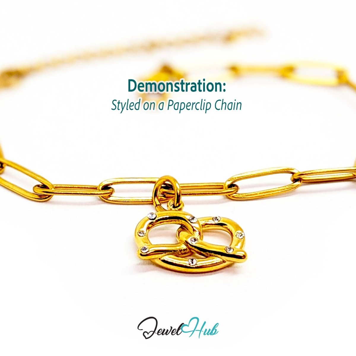Pretzel charm in gold stainless steel with clear crystals - styled on a gold paperclip chain bracelet - JewelHub