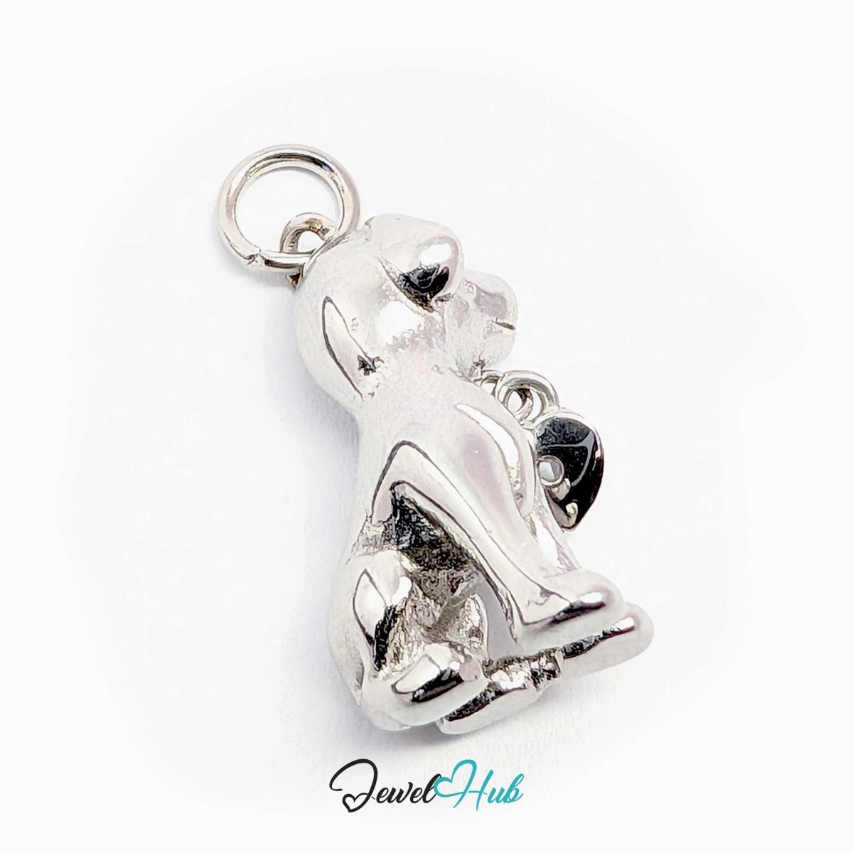 Silver sitting puppy charm laid on its side to show the sculpted paws and tail - JewelHub