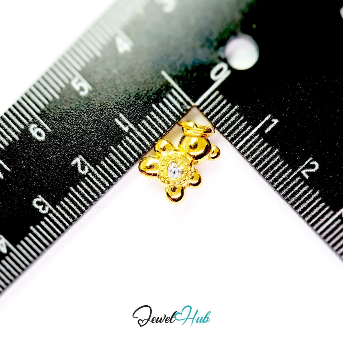 Small gold Crystal Solitaire Heart Bear charm measured against a ruler at 11mm wide by 14mm tall - JewelHub
