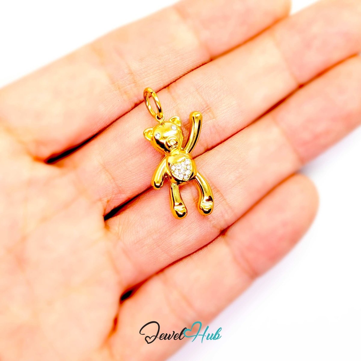 Gold Crystal Tummy Bear charm held in the hand to show its 22mm scale - JewelHub