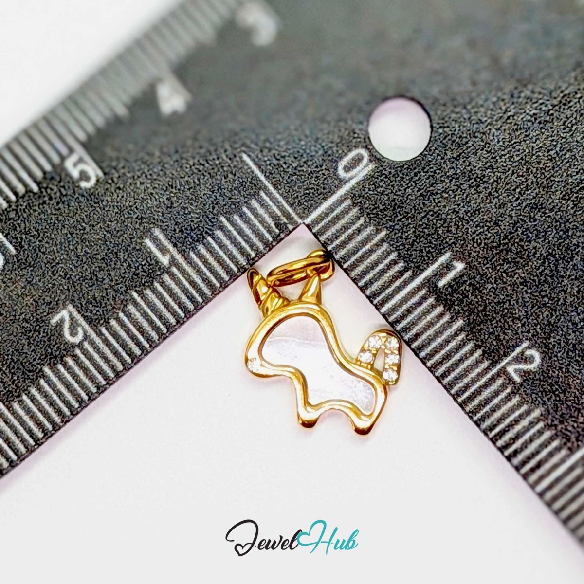 Gold unicorn charm measured against a ruler at 17mm wide by 12mm tall - JewelHub