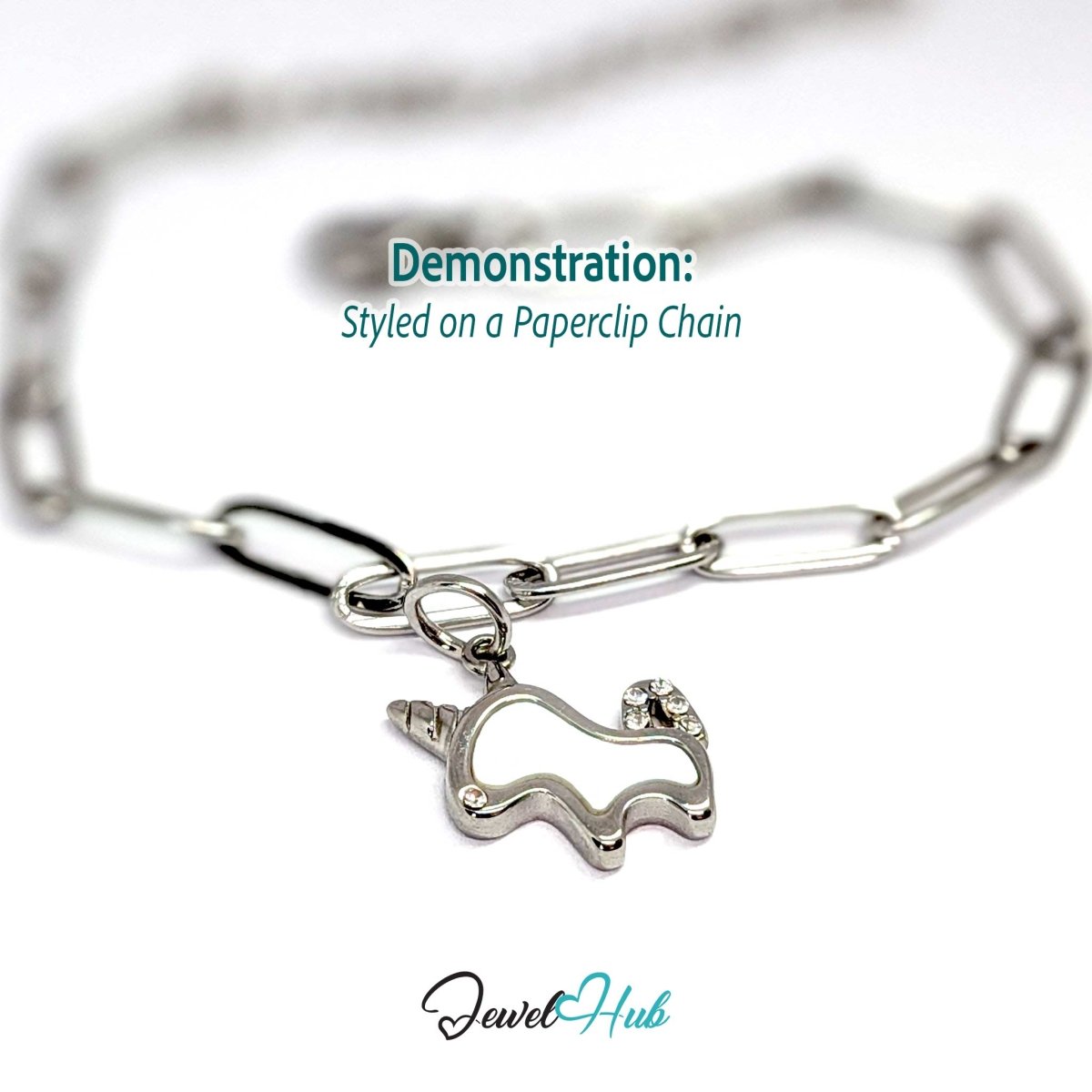 Silver unicorn charm hanging from a silver paperclip chain bracelet - JewelHub