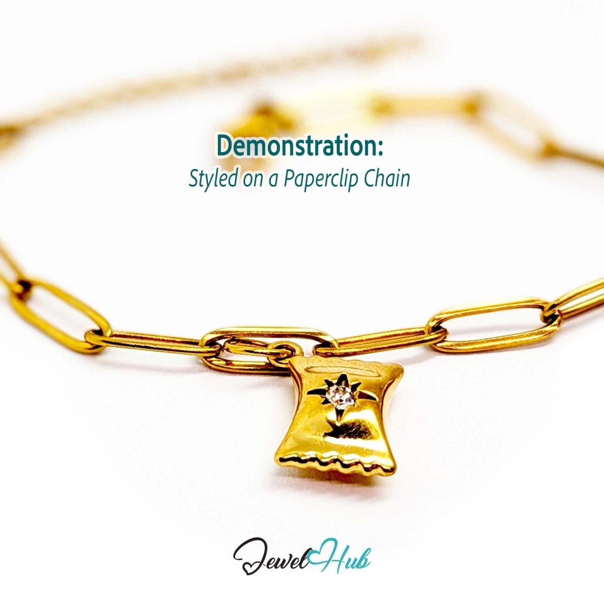 Wrapped sweet charm in gold stainless steel with a clear crystal - styled on a gold paperclip chain bracelet - JewelHub