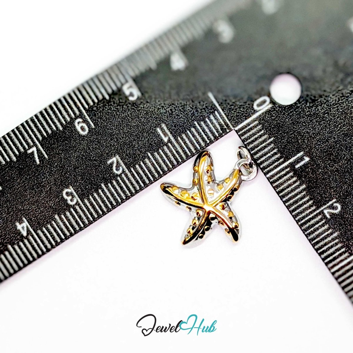 DuoTone starfish charm measured against a ruler at 16.6mm wide by 19.8mm tall - JewelHub