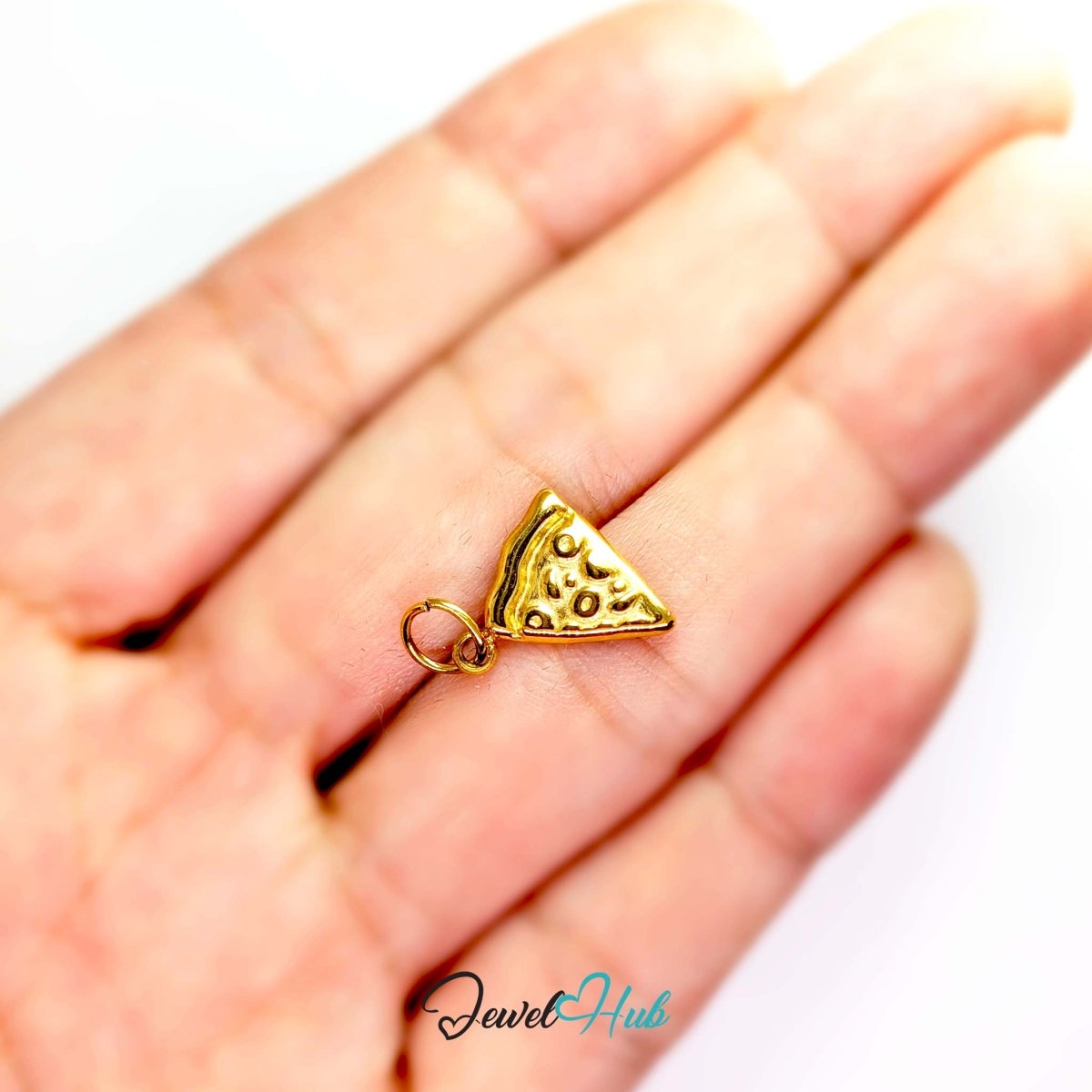 Embossed pizza slice charm in gold stainless steel - held in the hand for scale - JewelHub
