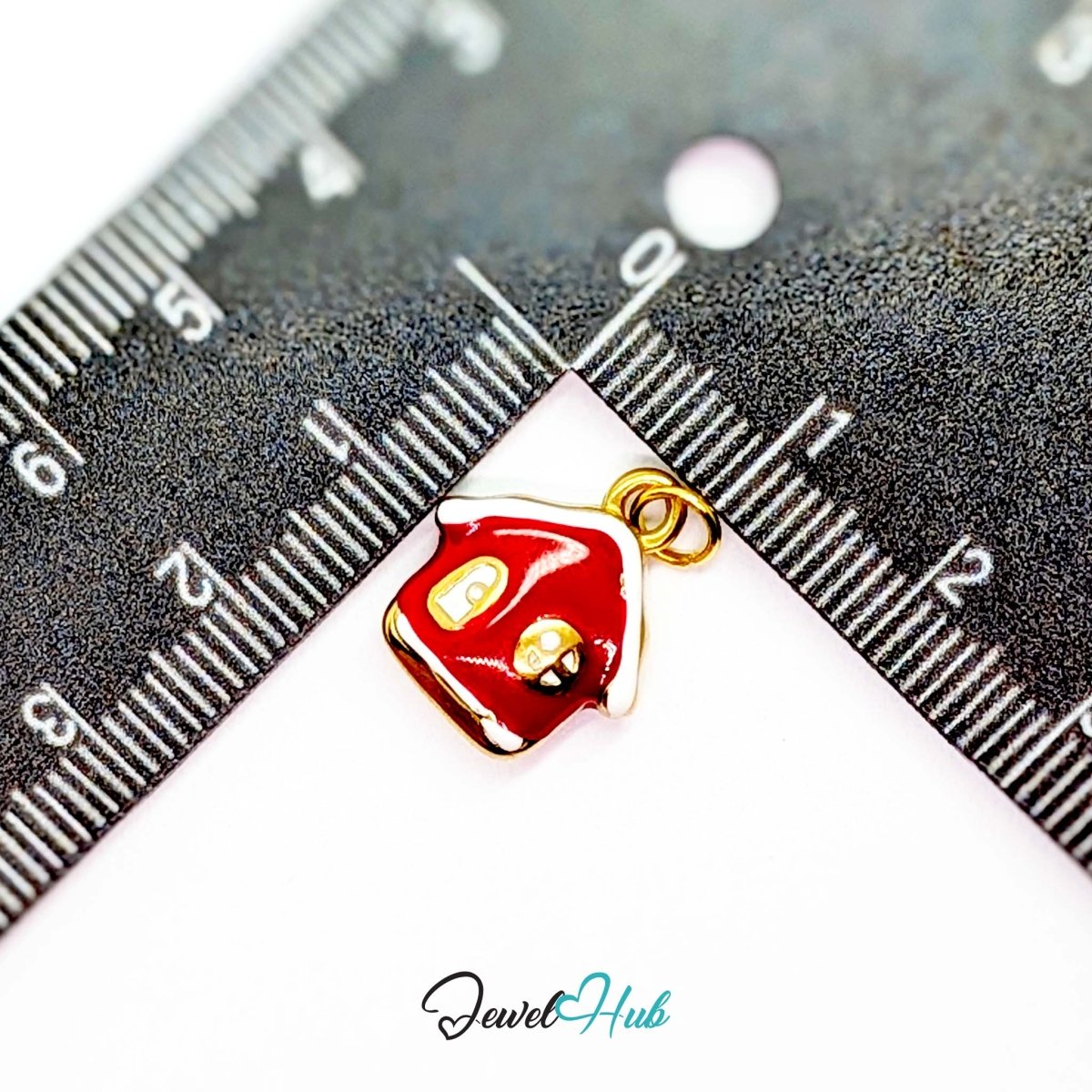 Red enamel house charm in gold stainless steel - beside a ruler for scale - JewelHub
