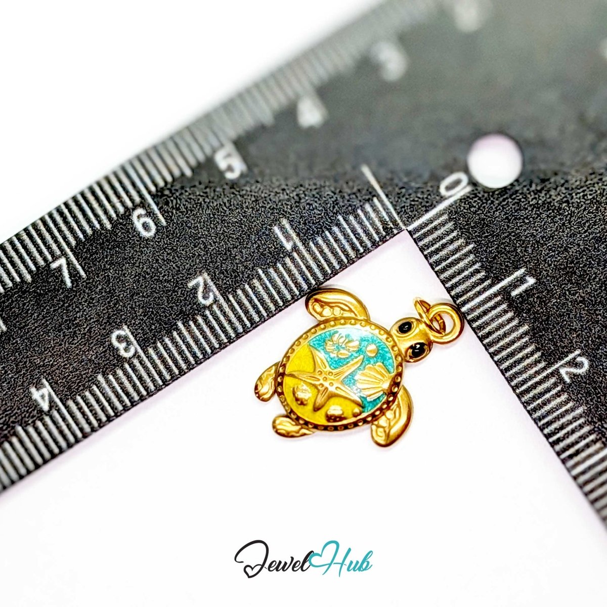 Turquoise sea turtle charm measured against a ruler at 17.6mm wide by 23.3mm tall - JewelHub