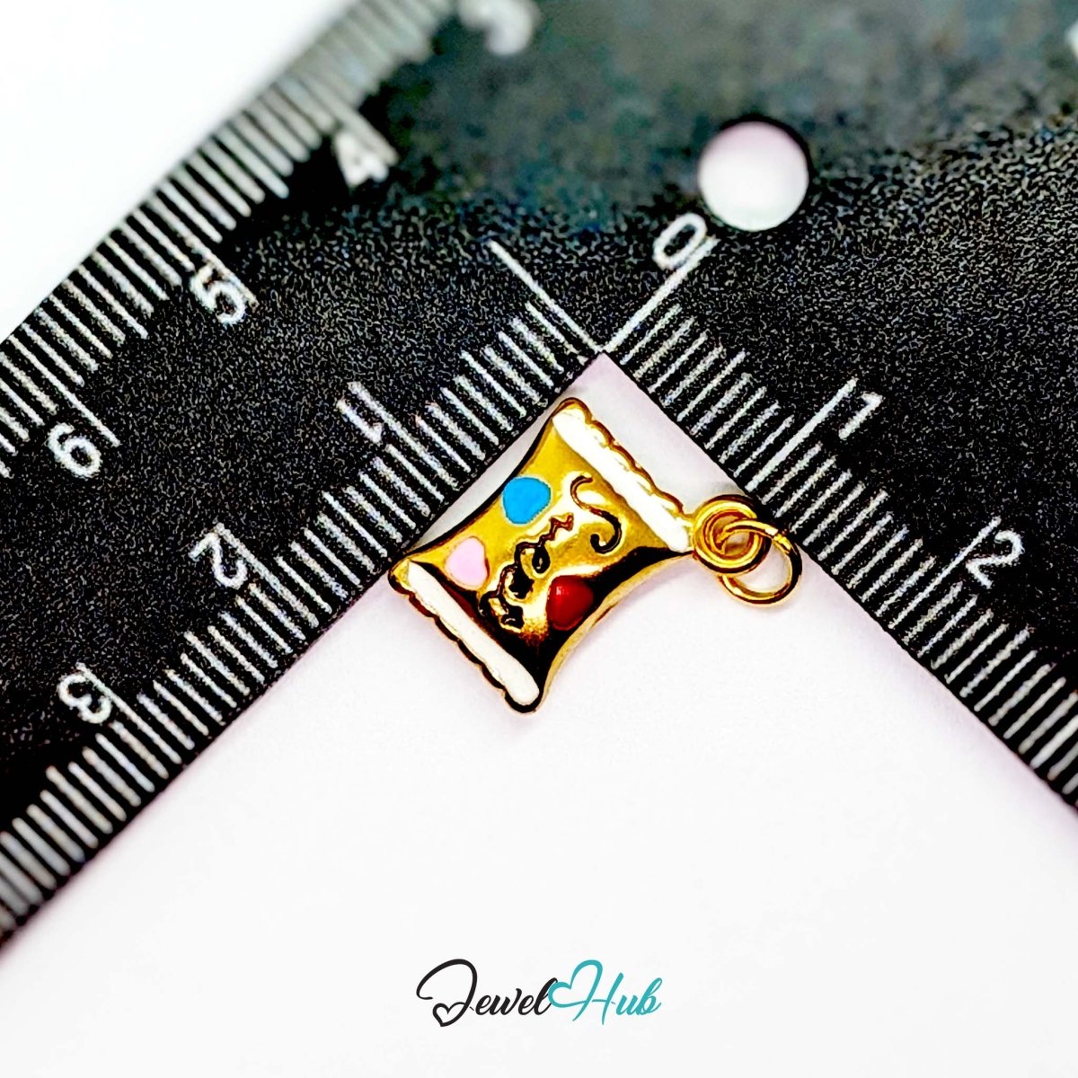 Enamel wrapped sweet charm in gold stainless steel - beside a ruler for scale - JewelHub