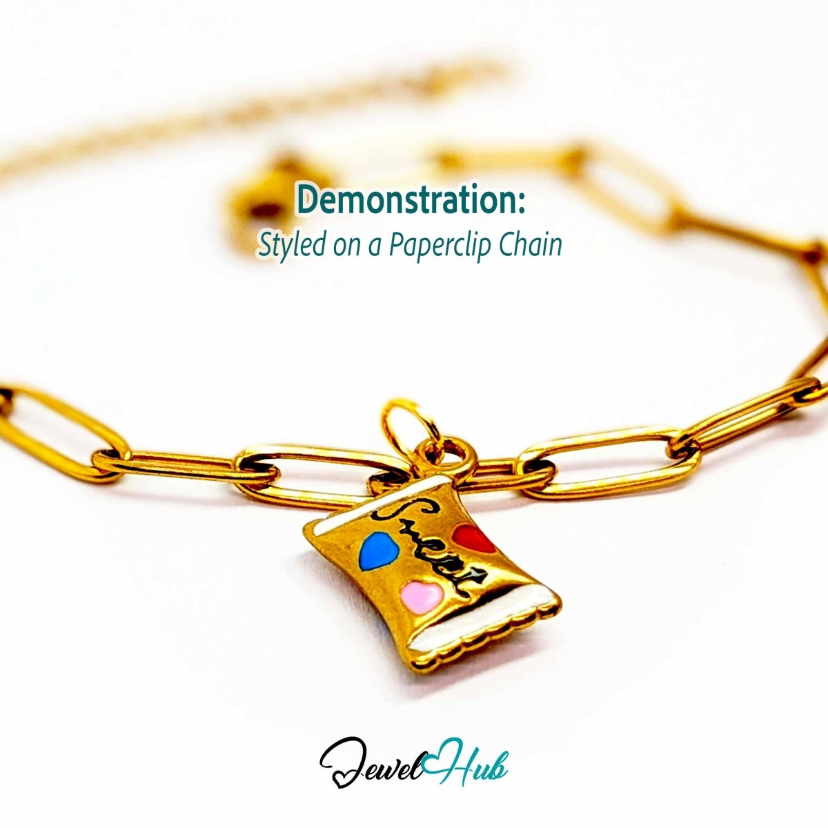 Enamel wrapped sweet charm in gold stainless steel - styled on a gold paperclip chain bracelet - JewelHub