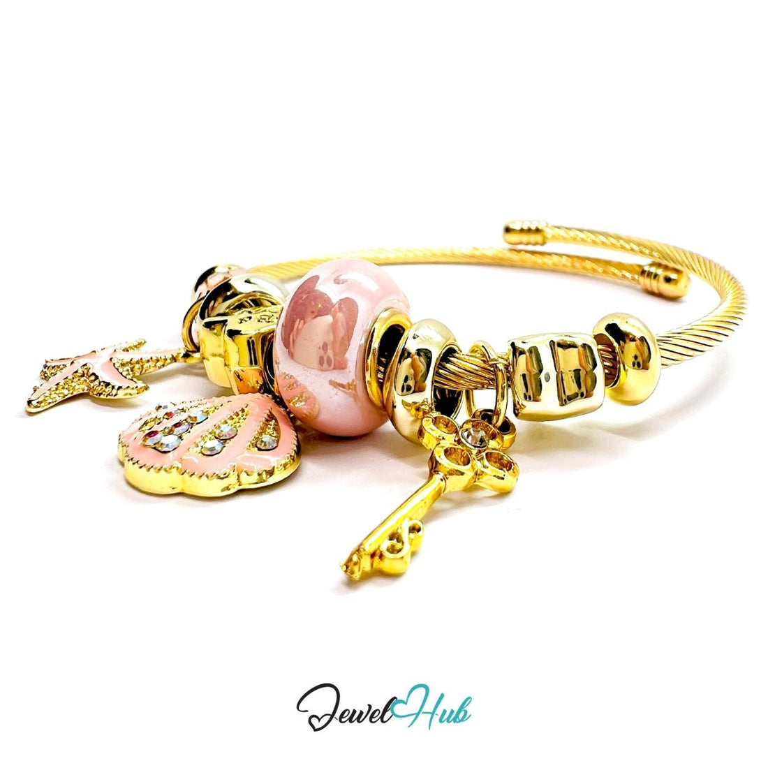 Gold bracelet with various charms including a heart, starfish, and shell on a white background.