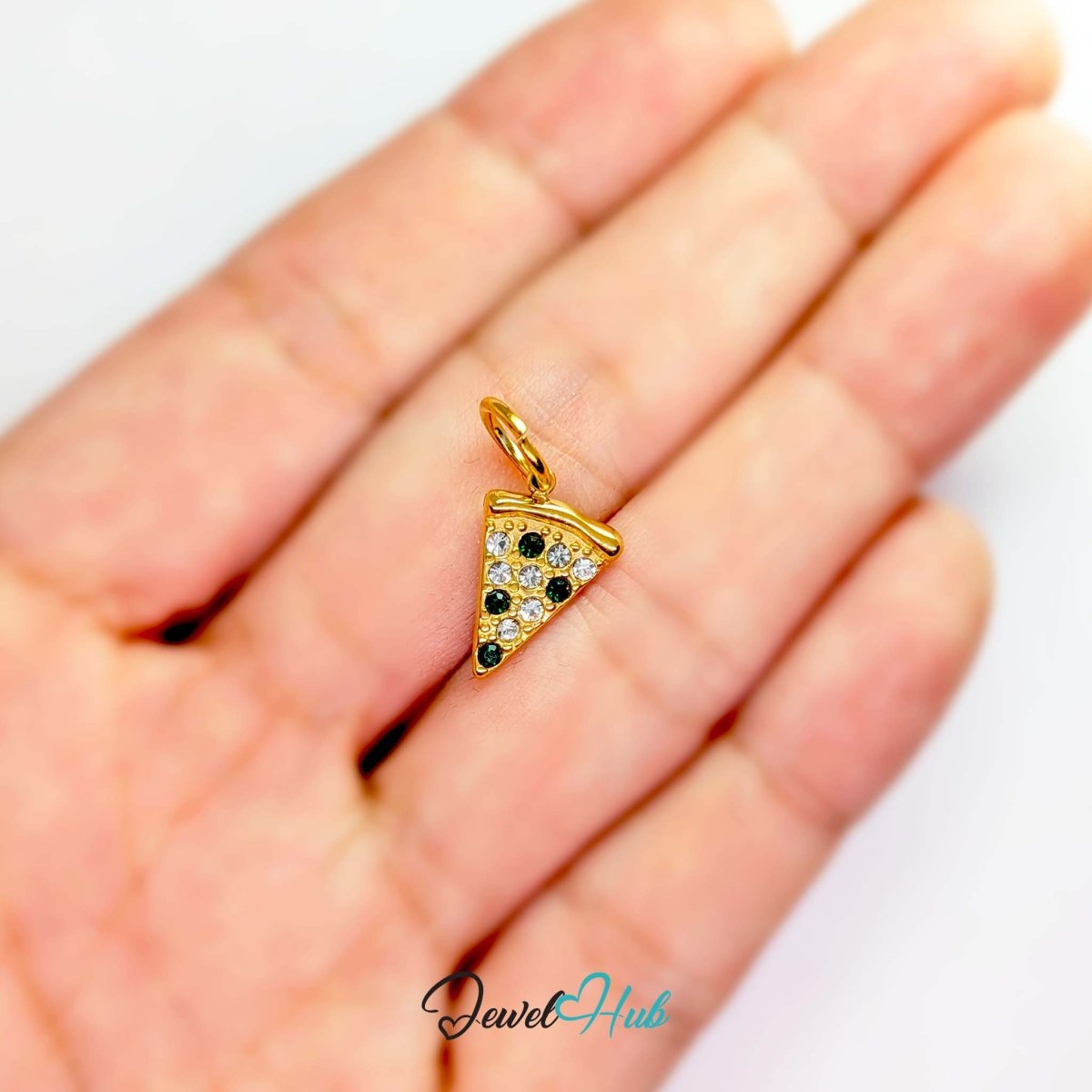 Pizza slice charm in gold stainless steel set with clear and dark green crystals - held in the hand for scale - JewelHub