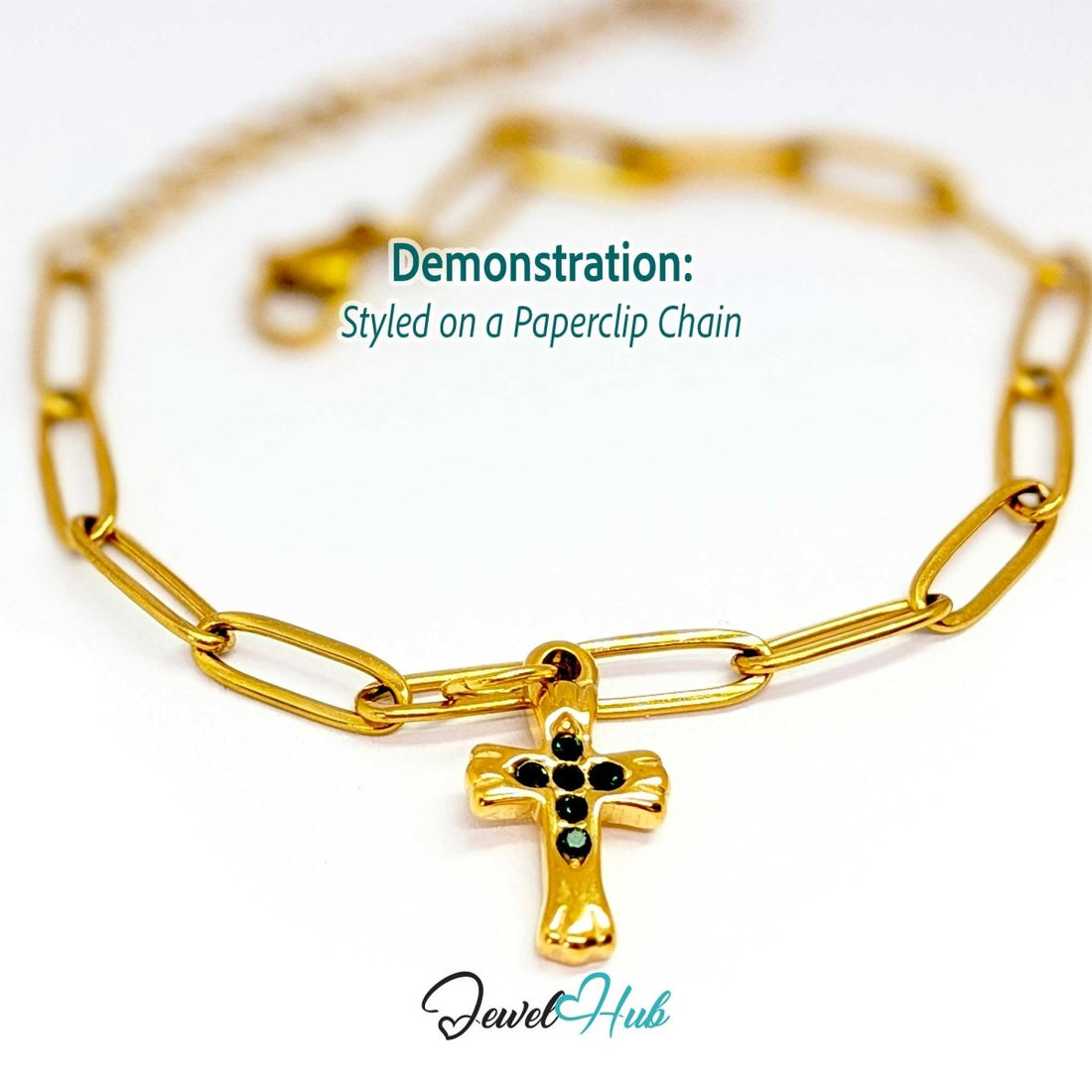 Small cross charm in gold stainless steel with six green stones - styled on a gold paperclip chain bracelet - JewelHub