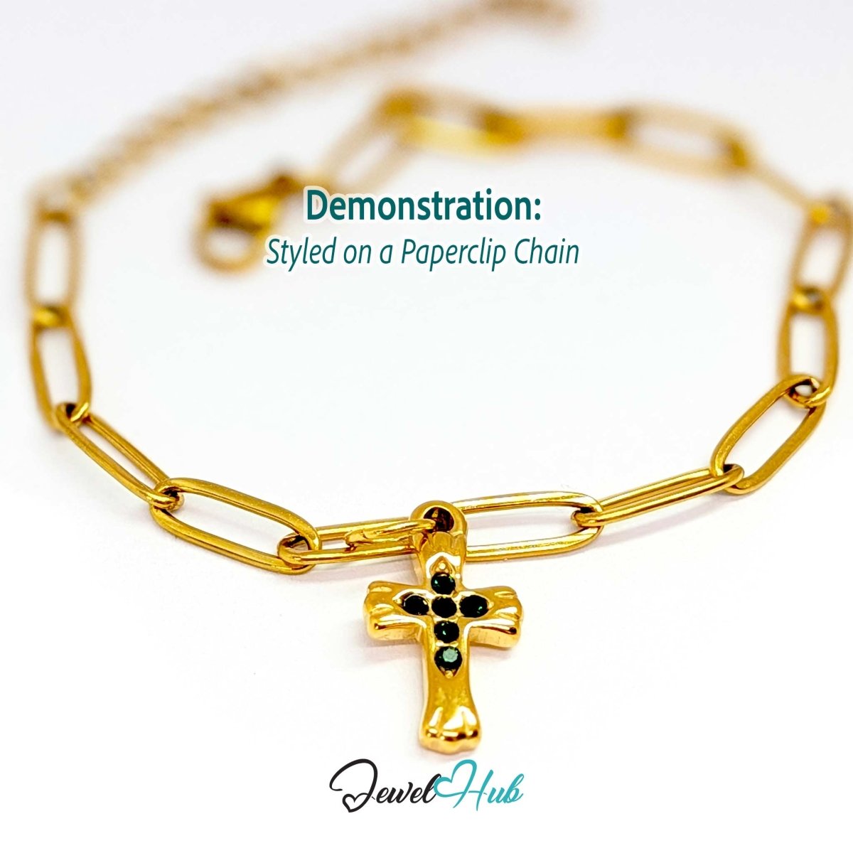 Small cross charm in gold stainless steel with six green stones - styled on a gold paperclip chain bracelet - JewelHub