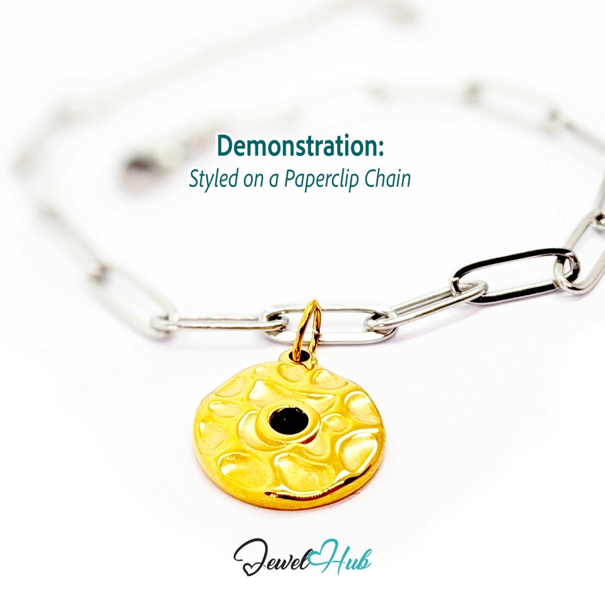 Hammered disc charm in gold stainless steel with a green stone - styled on a silver paperclip chain bracelet - JewelHub
